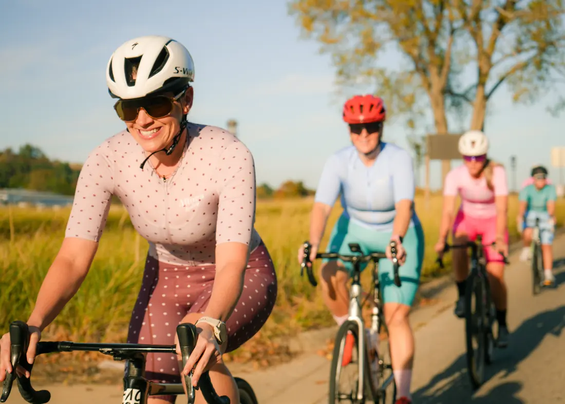 Riders in Allora kits laughing together at a stoplight-free stretch